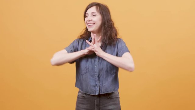 Pretty young woman finding out good news and gets excited. Isolated portrait of a young female over yellow background.