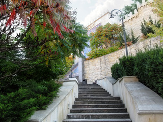 Kiev, Ukraine - October 8, 2018: Staircase leading to fountain-waterfall in Heydar Aliyev Park (Kiev). Landscape in the Middle Eastern style - granite staircase near a stone wall among exotic greenery