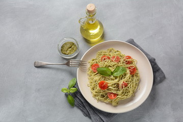 Pasta spaghetti with pesto sauce, fresh basil and cherry tomatoes . Italian traditional food