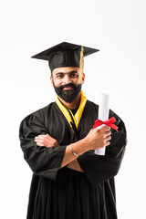 education, graduation and people concept - happy Indian Male graduate student in mortarboard and...