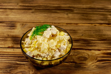 Festive salad with chicken breast, sweet corn, canned pineapple, cheese and mayonnaise on wooden table