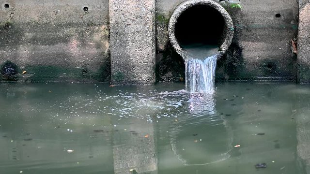 waste water flow to sewer with moss, bad water from city, water pollution, sewer drain pipe dirt sewage water drain to Wastewater Treatment.