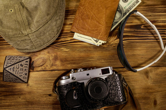 Travel vacation concept. Retro photo camera, hat, sunglasses, souvenir pyramid and passport with money on wooden background. Travel to Egypt. Top view, flat lay