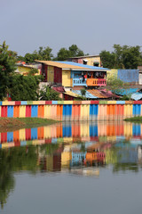 Fototapeta na wymiar Rainbow village in Indonesia, colorful houses and colorful dam along the canal of slum.