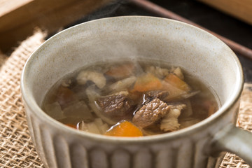 ほんのり湯気の立つ、牛ばら肉と野菜のコンソメスープ