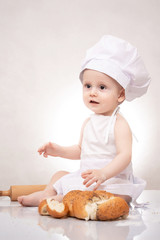 Small child cooks a croissant with bread. laughing happily
