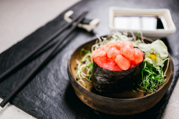 Sushi rolls, seafood delicacy, menu background, Japanese fusion restaurant concept. Japanese food art, expensive meals. Tuna gunkan maki with sauce and chopsticks