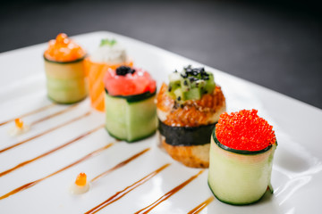 Sushi rolls degustation, fusion food style restaurant menu, deluxe gastronomy. Set of finest seafood snacks on white plate