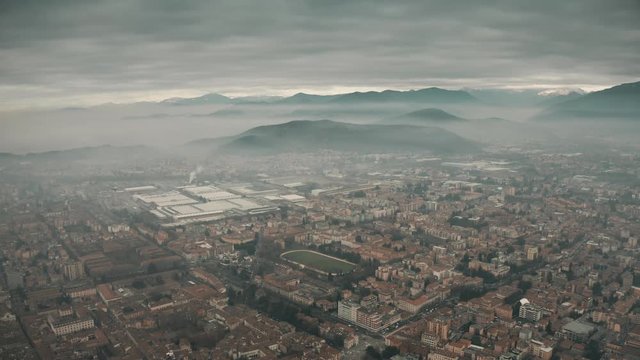 Aerial view of Brescia and surrounding mountains in fog, Italy