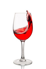 Red wine splashes into a glass isolated on white background. 
