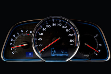Fototapeta premium The dashboard of the car is glowing blue with red arrows at night with a speedometer, tachometer and other tools to monitor the condition of the vehicle in modern style on black isolated background