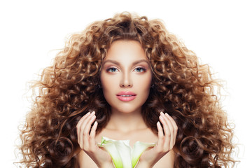 Beautiful young woman with long curly hair, clear skin and lily flower isolated on white