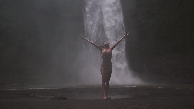 Beautiful girl having fun at the waterfalls in Bali. Concept about wanderlust traveling and wilderness culture