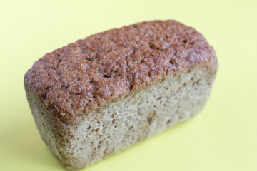 loaf of bread, healthy whole grain bread on a yellow background, close-up, selective focus