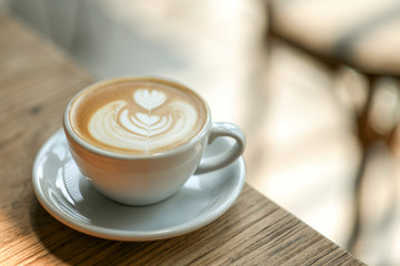 Coffee heart shape o n wood table in cafe.close-up shoot.