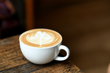 Latte coffee leaf shaped on a wooden table.