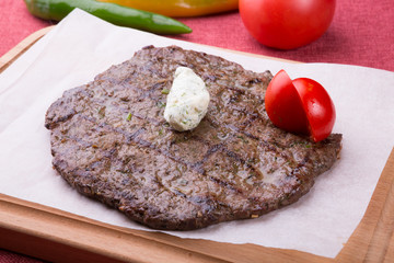 Fried horse meat steak served on wooden board