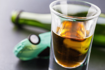 Concept of driving while intoxicated. A glass of whiskey with a bottle and an inverted machine. Human weakness and public safety