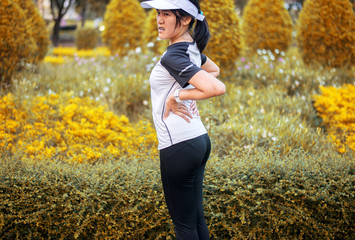Sporty asian female suffering from pain in waist  injury after sport exercise running jogging and...
