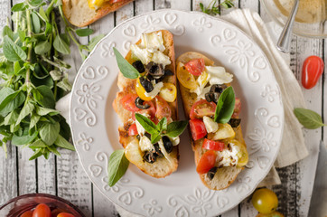 Crostini with tomatoes and olives on beautiful plate