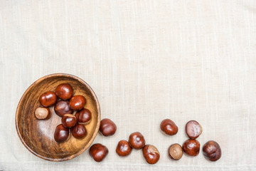 Chestnuts in wooden bowl with your place for the text. Top view