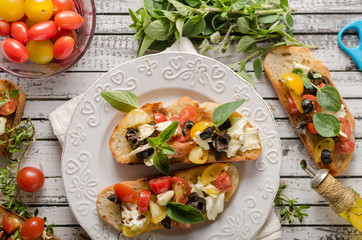 Crostini with tomatoes and olives on beautiful plate