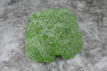 Top view of broccoli on grey,black and white floor.