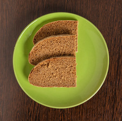 Pieces of rye bread lie on a plate on the table.