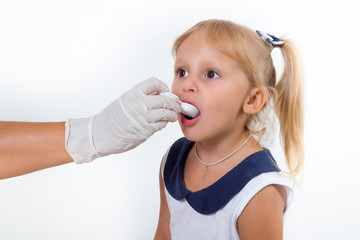 Doctor hand giving spoon dose of medicine liquid drinking syrup to child