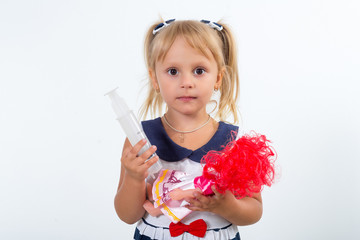 A little girl is playing doctor with a syringe in the river.