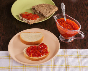 Pieces of rye bread and thick tomato sauce on a plate on the table.