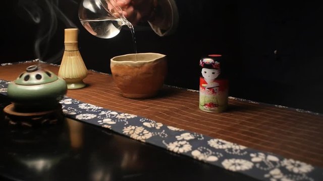 Master pours specially prepared water for cooking Japanese tea Matthia