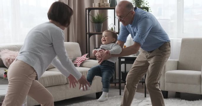 Grandparents enjoying with baby granddaughter at home