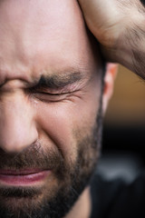 Obraz premium partial view of depressed bearded man crying with closed eyes