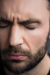 Obraz premium portrait of handsome, bearded depressed man crying with closed eyes
