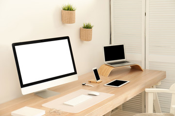 Stylish workplace interior with modern computer on table. Mockup for design