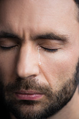 portrait of handsome depressed man crying with closed eyes