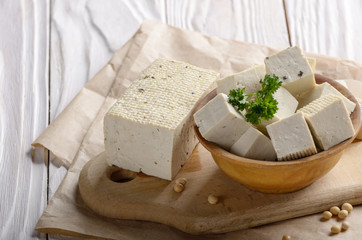 Soy Bean curd tofu in wooden bowl on kitchen table. Non-dairy alternative substitute for cheese