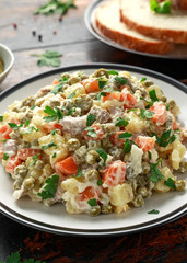 Russian traditional salad Olivier with vegetables and meat.