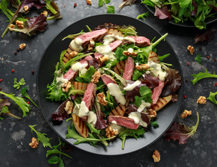 Grilled Beef Steak salad with pears, walnuts and greens vegetables and blue cheese sauce. healthy...
