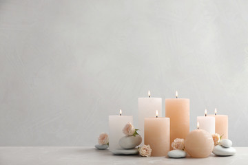 Fototapeta na wymiar Beautiful composition with candles on table against grey background. Space for text