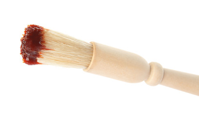Basting brush with barbecue sauce on white background