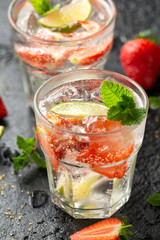 Strawberry Mojito cocktail with Rum, lime and mint in glass. Summer cold drink with ice