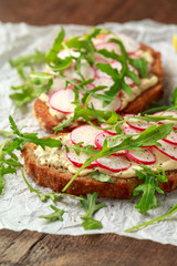 Hummus sourdough toast with reddish and wild rocket. Healthy vegan food