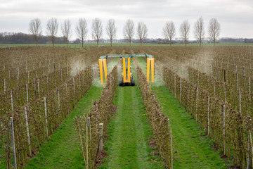 ASPEREN, THE NETHERLANDS - March 31, 2019: Modern orchard sprayer spraying insecticide or fungicide...