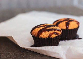 Homemade cupcakes with chocolate topping on a gray background. Selective focus, close-up.