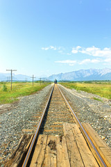 Fototapeta na wymiar Railway in mountains with train in distance