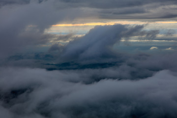 Abstract photograph above the clouds, sea of clouds effect, flying through the sky, aerial view, white puffy clouds and blue sky. Low pressure front atmospheric effect, cloudscape, cloudy weather