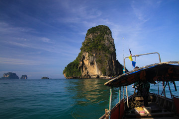 Boat Trip to isolated islands along steep cliffs in blue Andaman Sea near Ao Nang, Krabi, Thailand