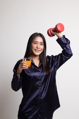 Young Asian woman with dumbbell drink orange juice.
